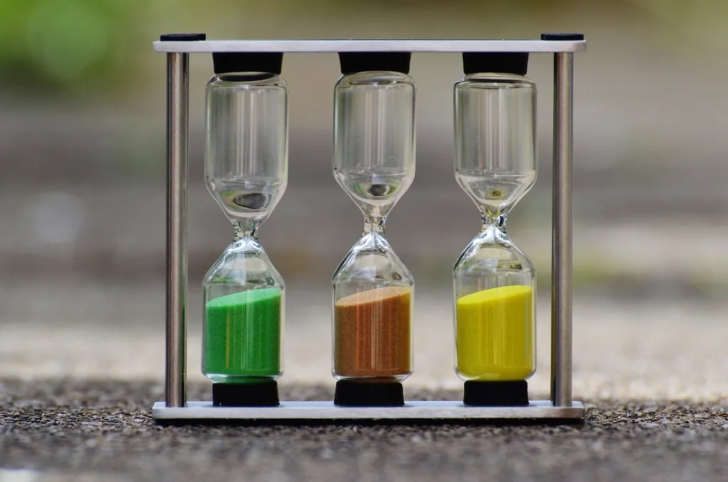 Three small hourglasses with green, orange and yellow sand