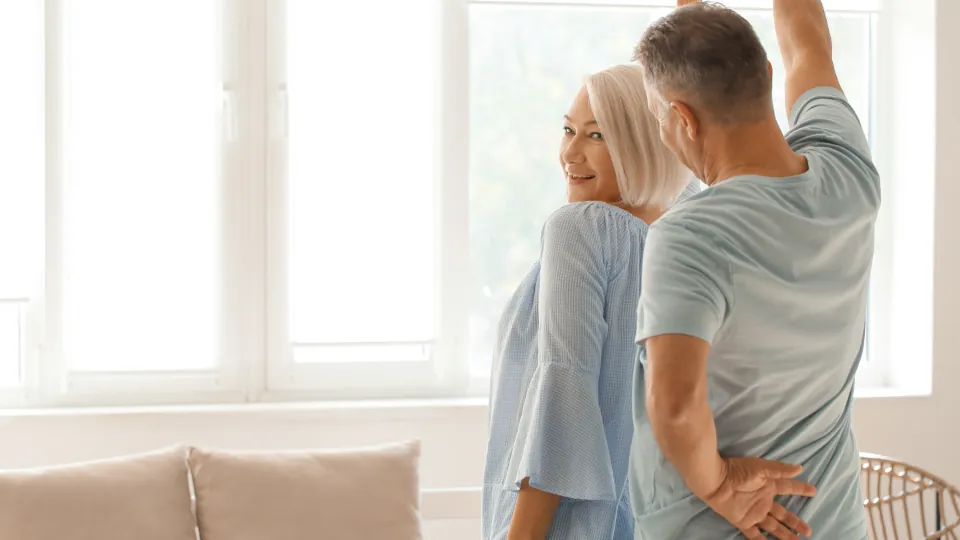 Couple practicing a turn at home between ballroom dance lessons in NJ