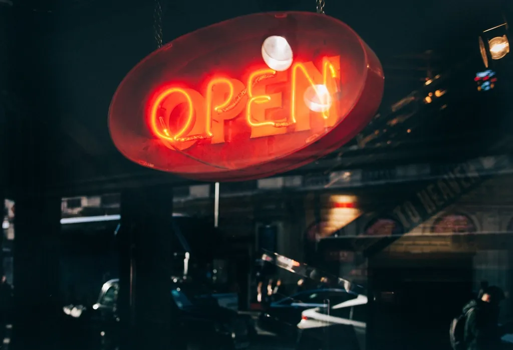 Red neon open sign glowing in a shop window at night