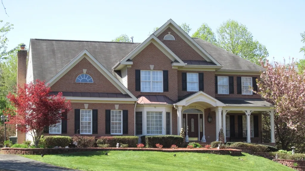 Brick colonial house with a sloping lawn, the kind of home to sell once you know how to choose a Realtor in NJ
