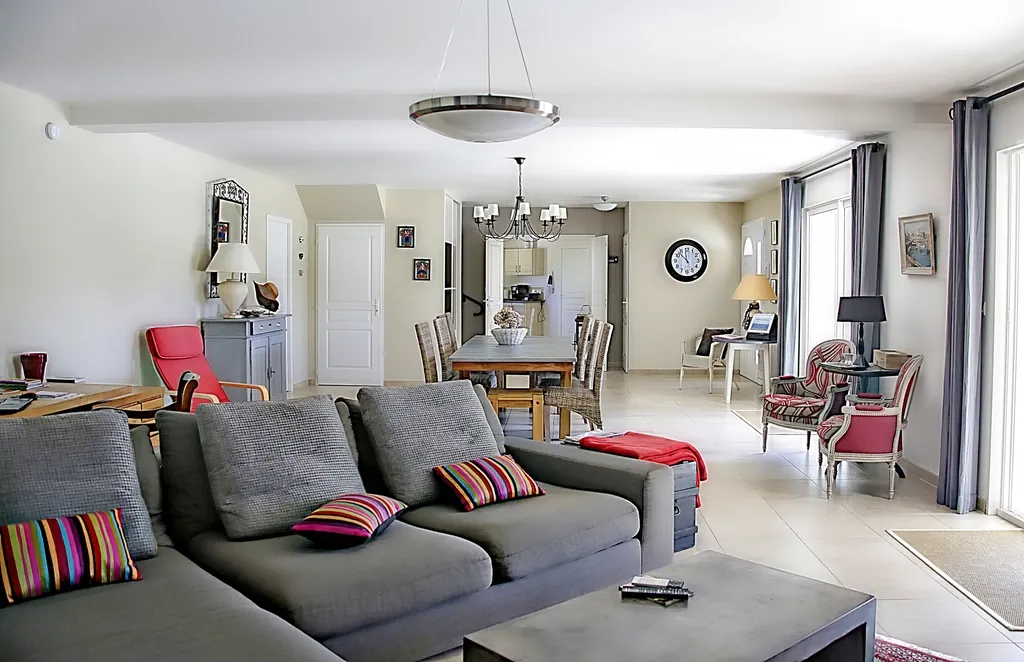 Open living and dining area with a gray sofa and a long table