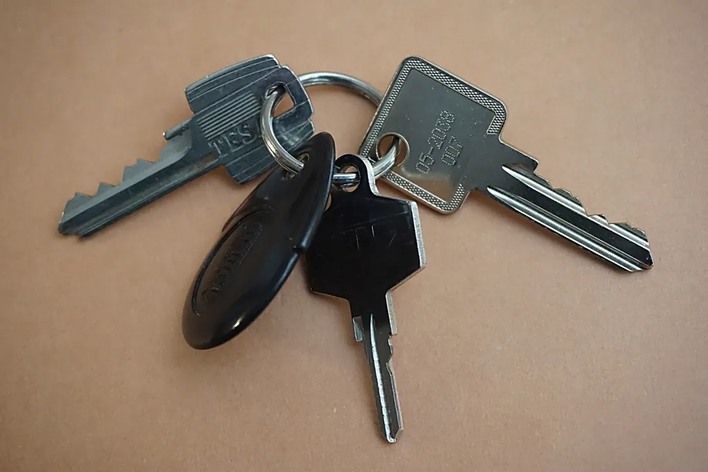 Ring of house keys lying on a tan table