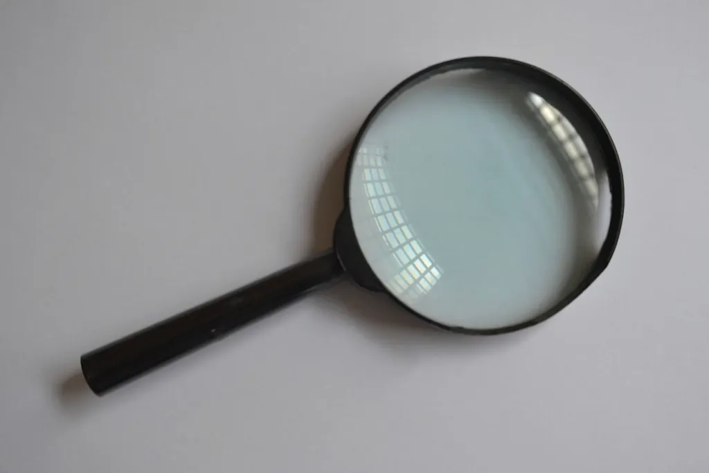 Black magnifying glass lying on a gray surface