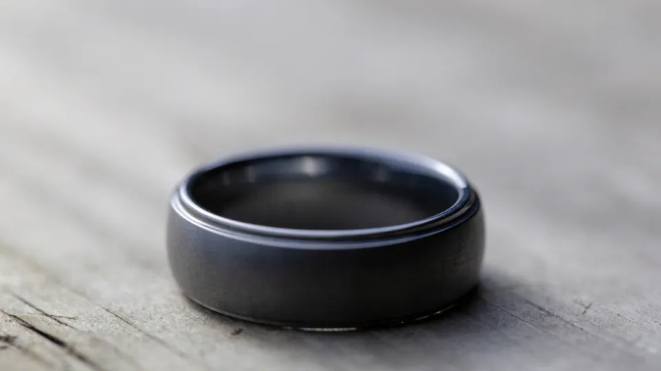 Single wedding band resting on a wooden table, a quiet symbol of the divorce process in NJ