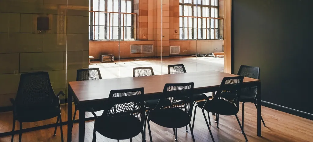 Small meeting room with a wooden table and black chairs