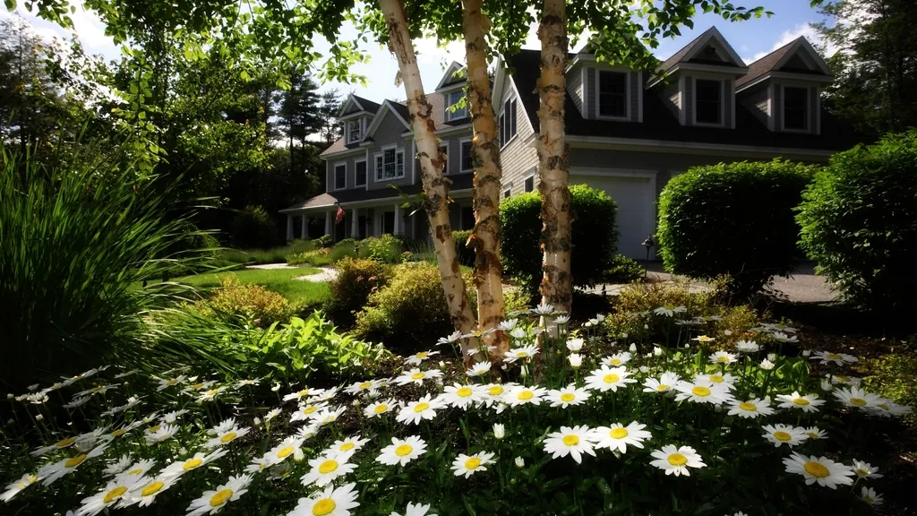Two-story home behind a garden of white daisies, ready for exterior house painting in NJ
