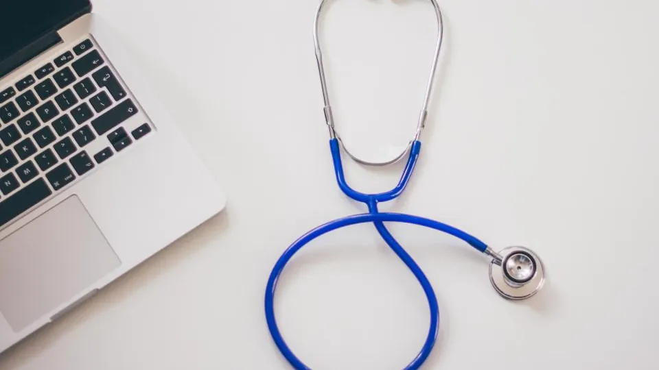 Stethoscope beside a laptop, a symbol of group health insurance in NJ for small businesses