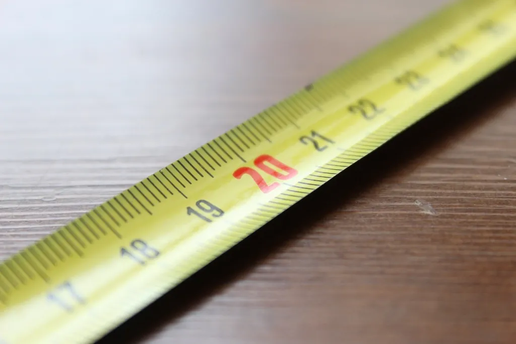 Yellow tape measure stretched across a wooden table