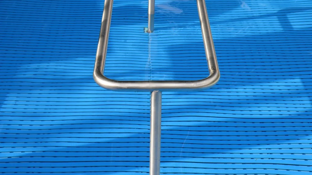 Pool ladder rail in clear blue water after a pool opening in NJ
