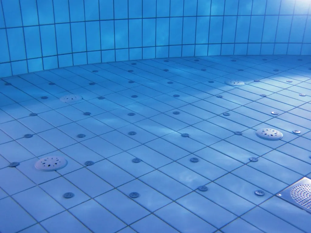 Tiled pool floor with drain and return fittings