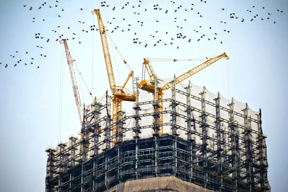Cranes above a high-rise building under construction