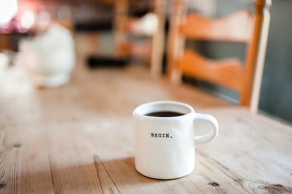White coffee mug with a one-word message on a wooden table