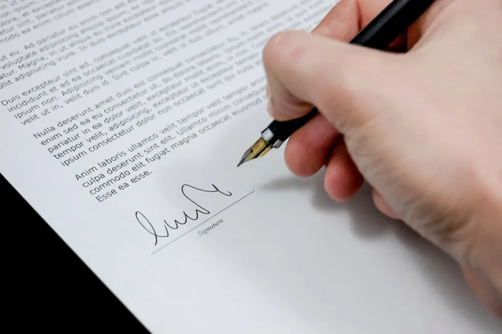 Buyer signing closing documents with a pen